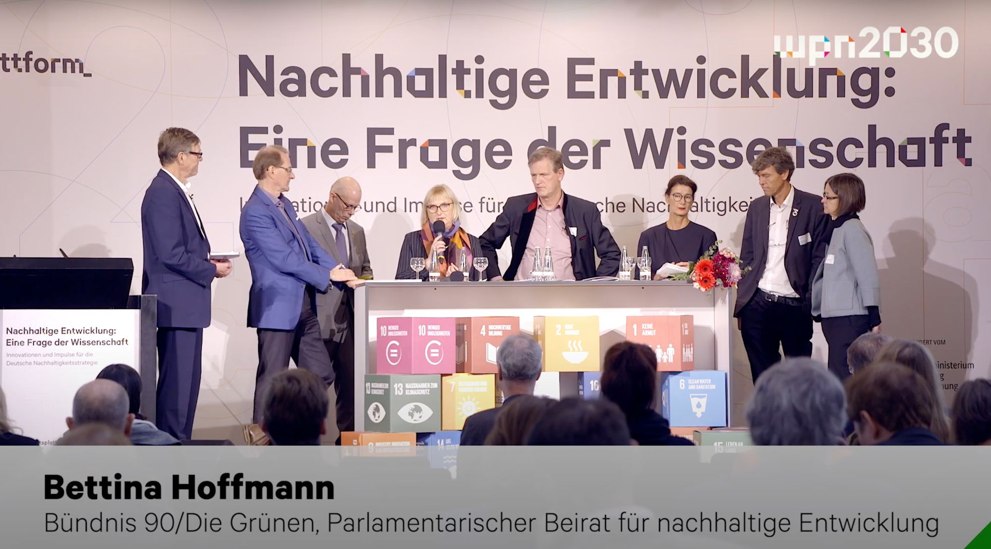 Mehrere Personen auf einer Bühne vor dem Schriftzug „Nachhaltige Entwicklung: Eine Frage der Wissenschaft“