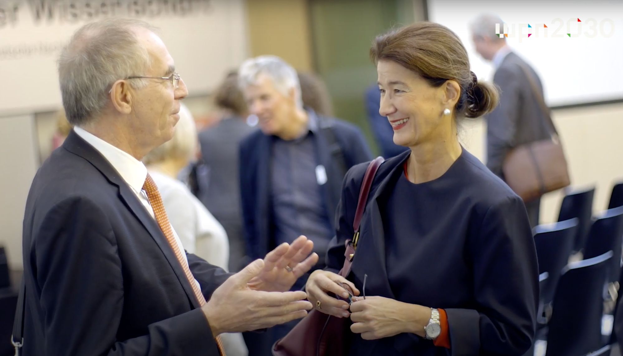 Mann und Frau im Gespräch am Rande einer Konferenz
