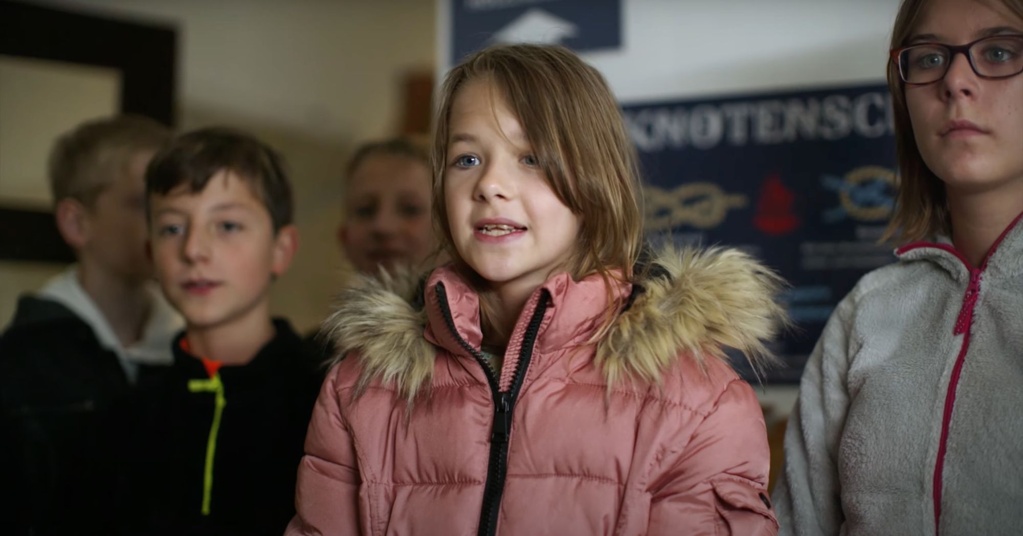 Kinder vor einer Schautafel zu Knoten, Mädchen im Vordergrund spricht