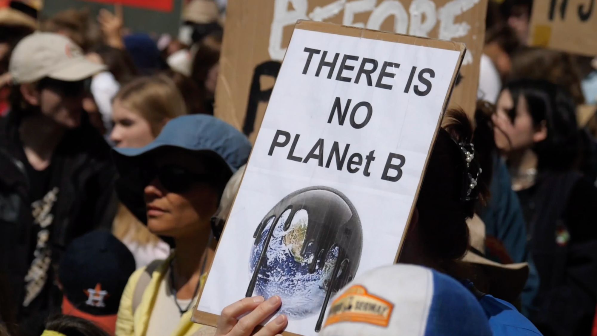 Demoschild mit der Aufschrift „There is no PLANet B“ und schmelzender Erde