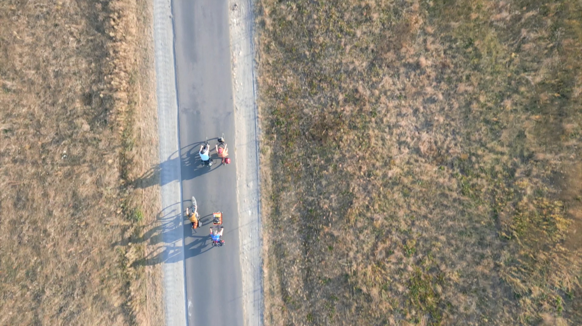 Aerial view of four cyclists on a field track